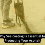 A person applying sealant to asphalt pavement with a cone nearby. Text overlay reads "Why Sealcoating Is Essential for Protecting Your Asphalt.